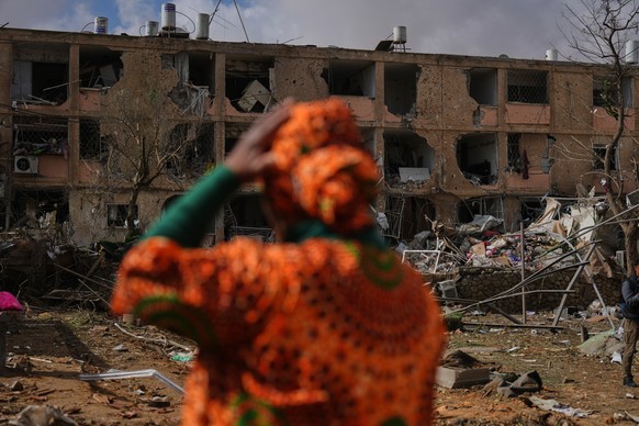 People survey a site that was struck by an Iranian missile in Dimona, southern Israel, Sunday, March 22, 2026. (AP Photo/Ariel Schalit)
Israel US Iran