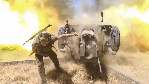 epa11562003 A still image taken from an undated handout video made available by the Russian Defence Ministry Press-Service on 23 August 2024 shows Russian servicemen firing a 122-mm howitzer D-30 towa ...