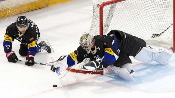 Fribourg&#039;s goaltender Reto Berra, right, saves a puck past Fribourg&#039;s defender Mauro Dufner, left, during the game of National League A (NLA) Swiss Championship between HC Fribourg Gotteron  ...
