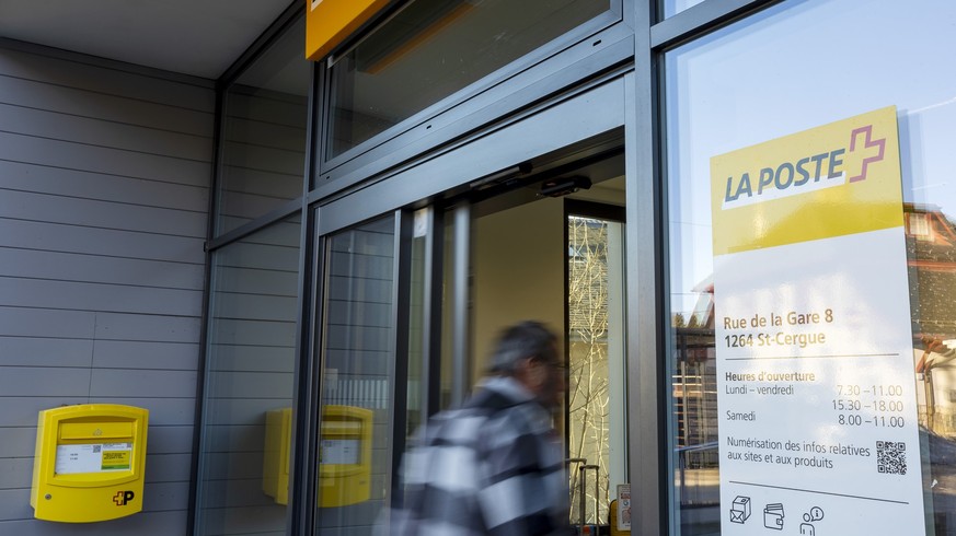 Un client arrive a l&#039;office postale, menacee de fermeture par La Poste, ou la commune a deploye une banderole &quot;Oui au maintien de notre bureau de poste!&quot; devant l&#039;entree, ce vendre ...