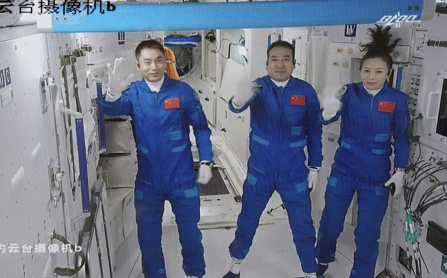 In this photo released by Xinhua News Agency, screen image captured at Beijing Aerospace Control Center in Beijing, China, Saturday, Oct. 16, 2021 shows three Chinese astronauts, from left, Ye Guangfu ...