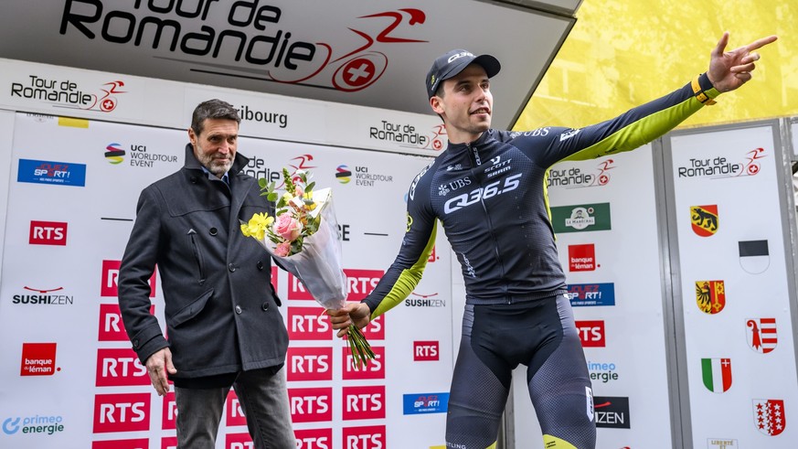 Fabio Christen from Switzerland of Q36.5 Pro Cycling team celebrates on the podium next to RTS TV sport director Massimo Lorenzi during the first stage, a 165,7 km race between Chateau-d'Oex et F ...
