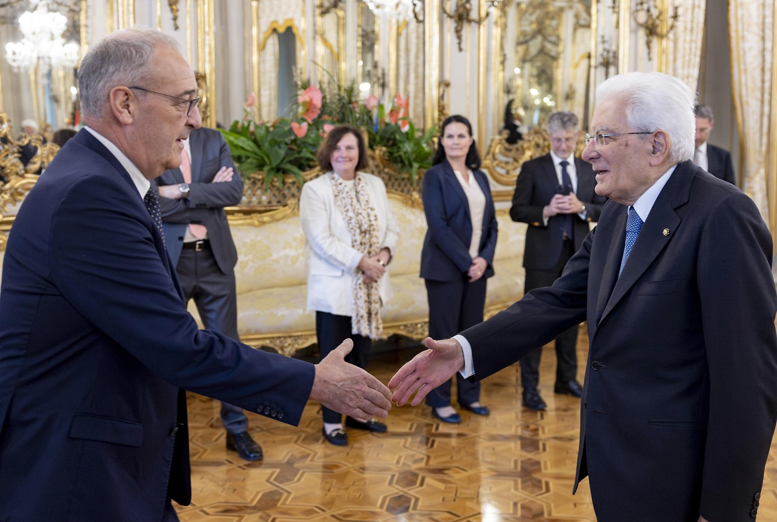epa12933996 A handout picture made available by the Quirinal Presidential Palace (Palazzo del Quirinale) Press Office shows Italian President Sergio Mattarella (R) welcoming Swiss President Guy Parmel ...