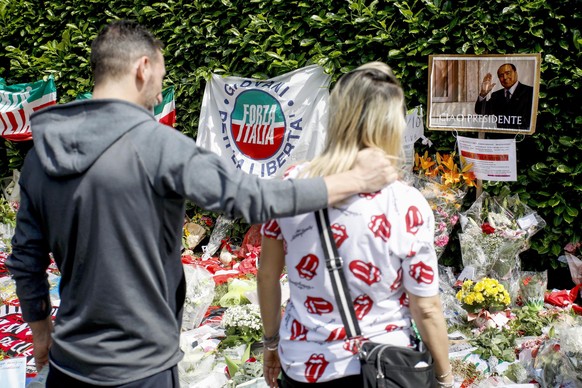 epaselect epa10690205 People stand in front of flowers and tributes placed outside Villa San Martino, the residence of former Italian prime minister Silvio Berlusconi, in Arcore, near Milan, northern  ...