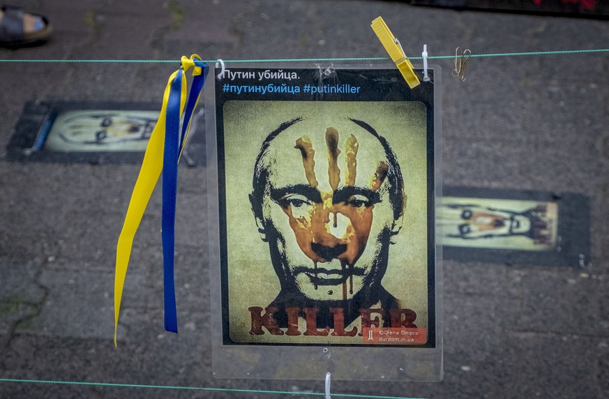A poster showing Russian President Putin is displayed as part of a vigil near the Russian consulate in Frankfurt, Germany, Saturday, June 24, 2023. (AP Photo/Michael Probst)