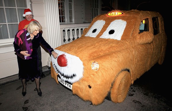 LONDON, ENGLAND - DECEMBER 06: Camilla, Duchess of Cornwall admires a taxi designed by driver Stephen Bell after they helped children from the Helen and Douglas House and London Taxi Driver&#039;s Fun ...