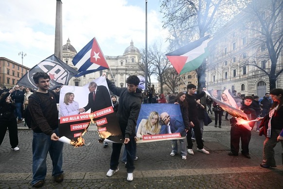Demonstrators tear and burn a poster depicting Italy's Prime Minister Giorgia Meloni and US president Trump while taking part in a rally organized by the "Social No" commitee to denounc ...