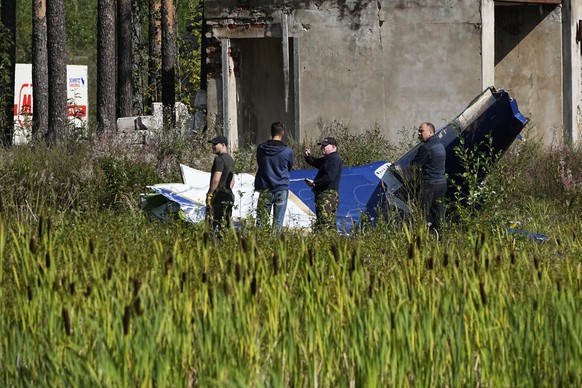 Russian servicemen inspect a part of a crashed private jet near the village of Kuzhenkino, Tver region, Russia, Thursday, Aug. 24, 2023. Russian mercenary leader Yevgeny Prigozhin, the founder of the  ...