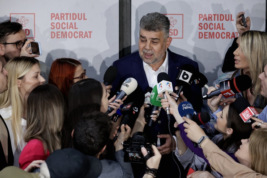 epa12075711 Romanian Prime Minister Marcel Ciolacu (C) announces his resignation to TV reporters after the first round of presidential elections held on Sunday, in front of the PSD party headquarters  ...