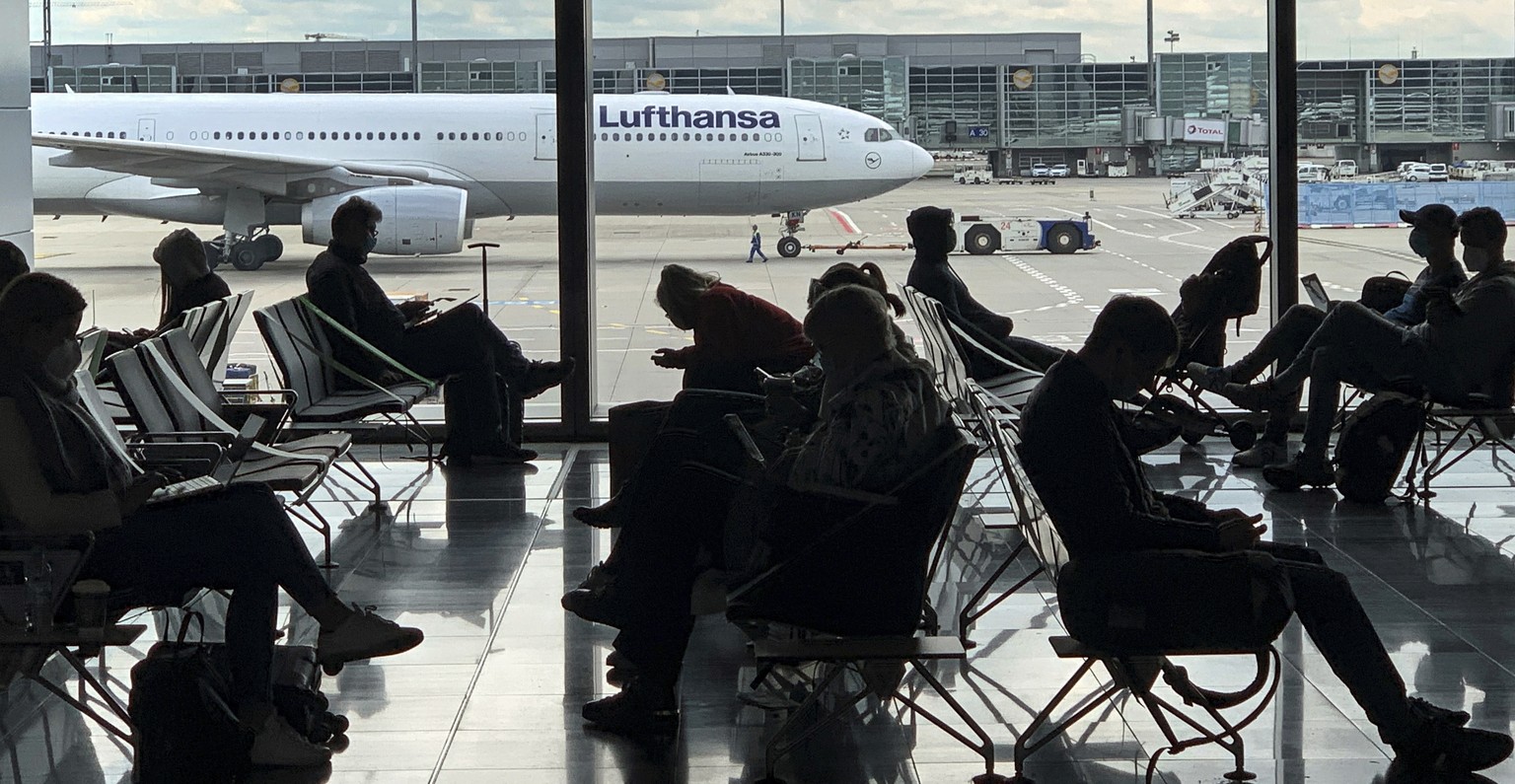 FILE -- Passengers wait for their Lufthansa flight at the airport in Frankfurt, Germany, Saturday, May 15, 2021. A union representing pilots at German carrier Lufthansa says they will stage a walk-out ...
