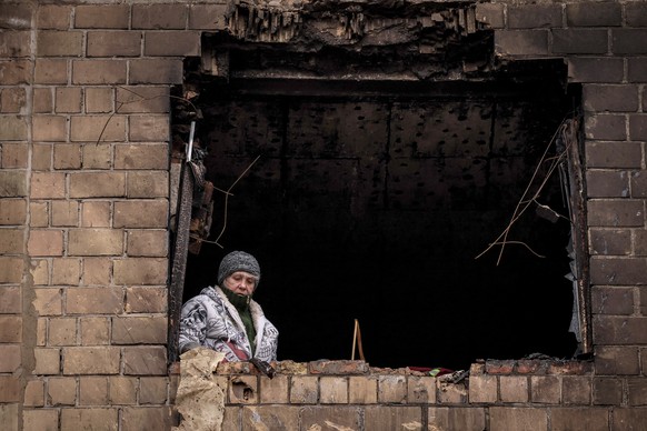 epa11098536 A local resident looks from a destroyed window of an apartment block after a rocket attack, in Kyiv (Kiev), Ukraine, 23 January 2024, amid the Russian invasion. At least 21 people were inj ...