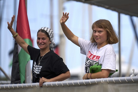 Swedish climate activist Greta Thunberg waves from a boat taking part in a civilian flotilla bound for Gaza, aiming to break the Israeli blockade and deliver humanitarian aid, in Barcelona, Spain, Sun ...