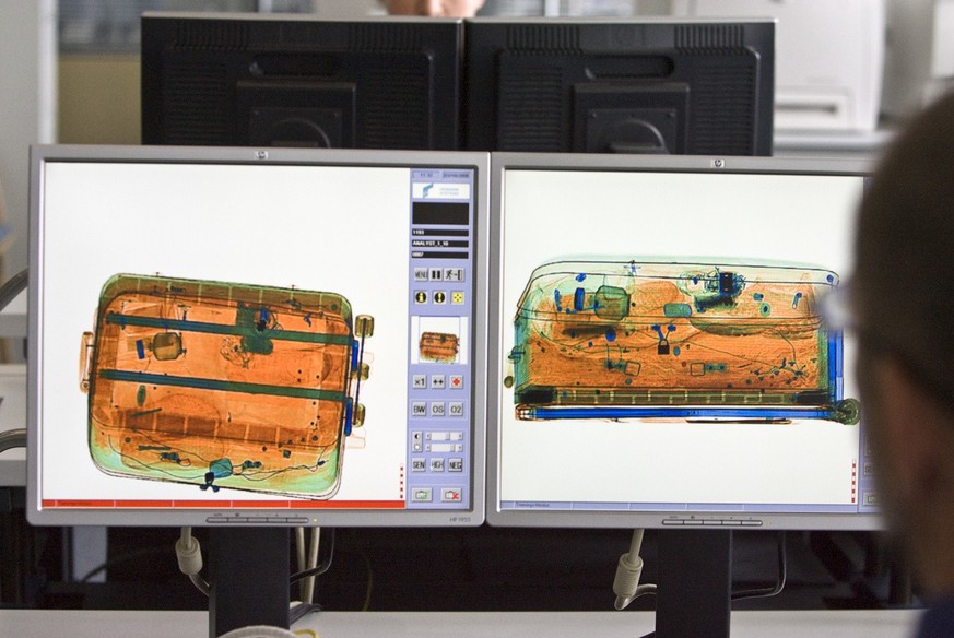 A security control staff member checks baggage in the cantonal police's office at Zurich's airport in Kloten in the canton of Zurich, Switzerland, pictured on October 3, 2008. This electroni ...