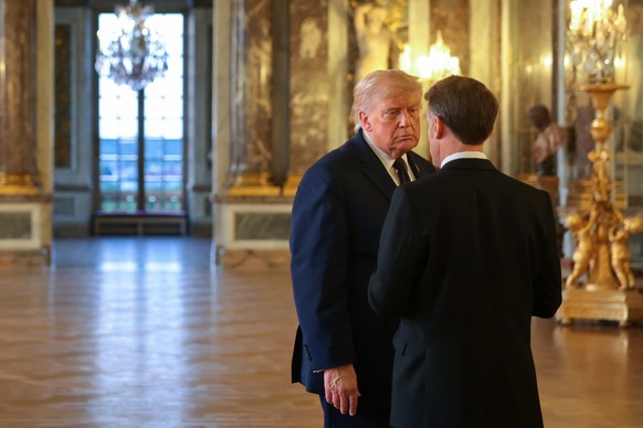 President Donald Trump speaks with President of France Emmanuel Macron as he receives a tour of Chateau de Versailles ahead of a dinner Wednesday, June 17, 2026 in Versailles, France. (Anna Moneymaker ...