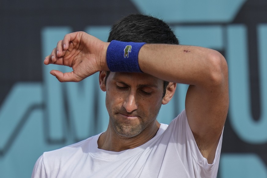 FILE - Novak Djokovic, of Serbia, wipes the sweat off during a training session at the Mutua Madrid Open tennis tournament in Madrid, Spain, on April 30, 2022. Djokovic withdrew from the upcoming hard ...