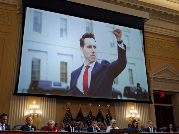 WASHINGTON, DC - JULY 21: A photograph of Sen. Josh Hawley (R-MO) pumping his fist toward the rioters on January 6, 2021 is shown during a prime-time hearing of the House Select Committee to Investiga ...