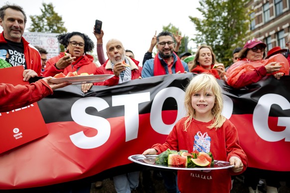 epa12432571 A girl hands out watermelon to protesters participating in a &#039;Red Line&#039; protest against Israel&#039;s military operations in the Gaza Strip and in support of the Palestinian peop ...