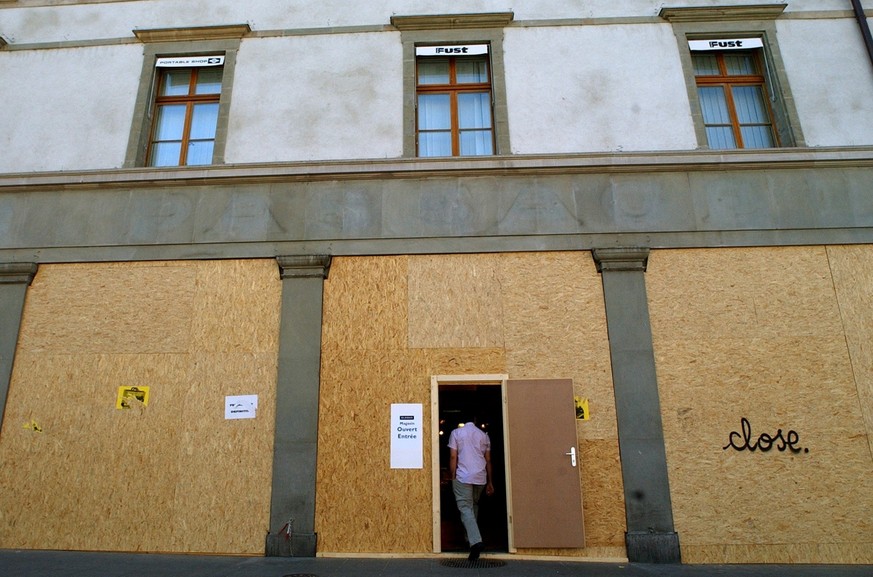 A man enters a boarded up storefronts in Geneva, Switzerland, Friday, May 30, 2003. The G8 summit will take place in Evian, France from June 1 to June 3 and brings together leaders of France, the Unit ...