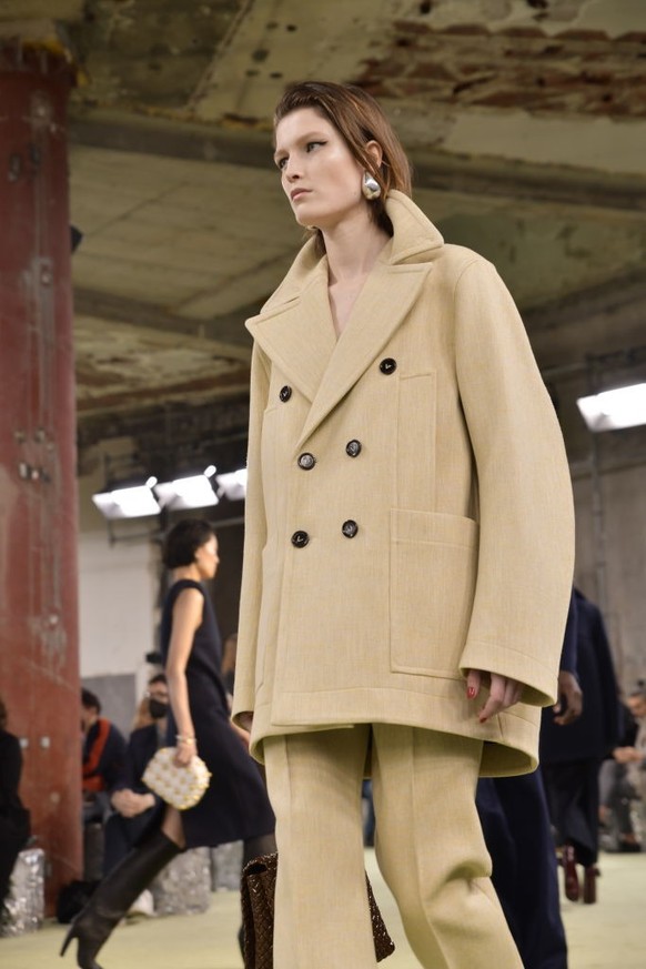 Model Tessa Bruinsma walks the runway in a molded camel colored peacoat and matching pants from the Bottega Veneta fall 2022 ready to wear collection. Fall 2022 marks the debut of creative director Ma ...