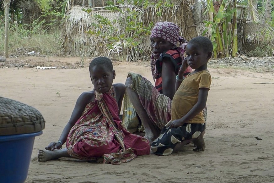 FILE - In this image made from video, residents watch as Rwandan soldiers patrol in the village of Mute, in Cabo Delgado province, Mozambique Monday, Aug. 9, 2021. Fleeing beheadings, shootings, rapes ...