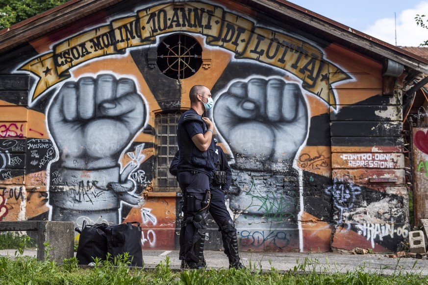 Ein Polizist steht neben dem abgressinen Autonomen Zentrum Molino (CSOA) in Lugano, am Sonntag, 30. Mai 2021. Die Raeumung und der Abriss erfolgten im Auftrag der Stadtverwaltung, wie die Tessiner Pol ...