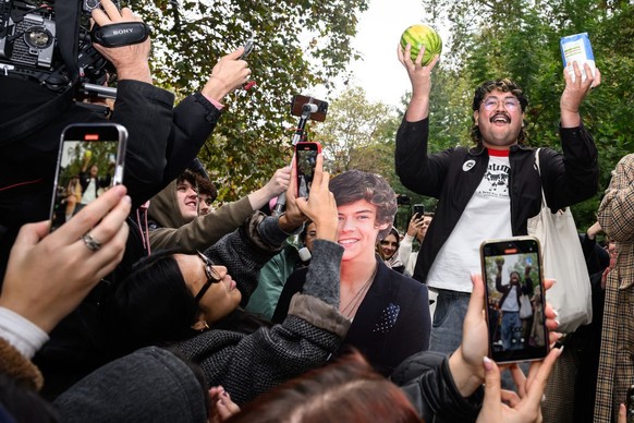 LONDON, ENGLAND - NOVEMBER 09: A contestant in a Harry Styles lookalike competition is cheered by fans of the former One Direction singer as he holds a watermelon and a bag of sugar, in Soho Square on ...