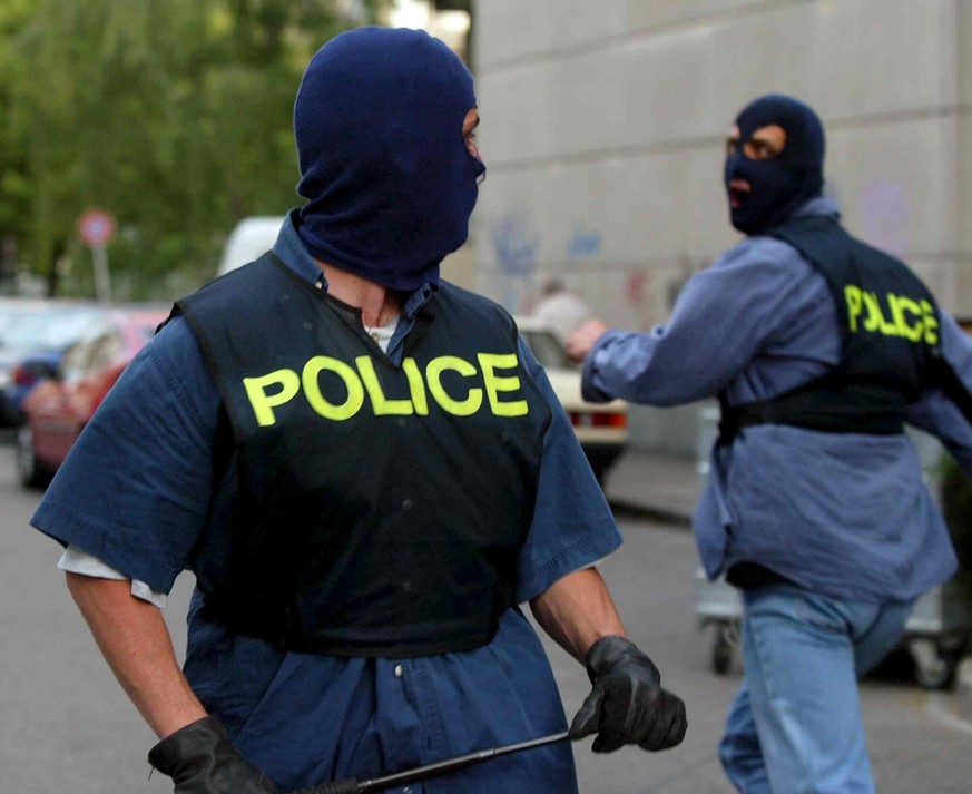 Two masked special riot policemen arrive to support their colleagues during clashes between anti-gloablisation demonstrators and riot police in Geneva, Switzerland, Tuesday, June 3, 2003. After the en ...