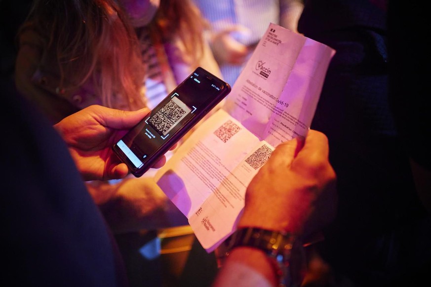 A security staff of the MAD (Moulin a Danse) night club scans the QR code of a COVID-19 certificate allowing entry in newly reopened nightclubs in Lausanne, Switzerland, late Friday, June 25, 2021. (K ...