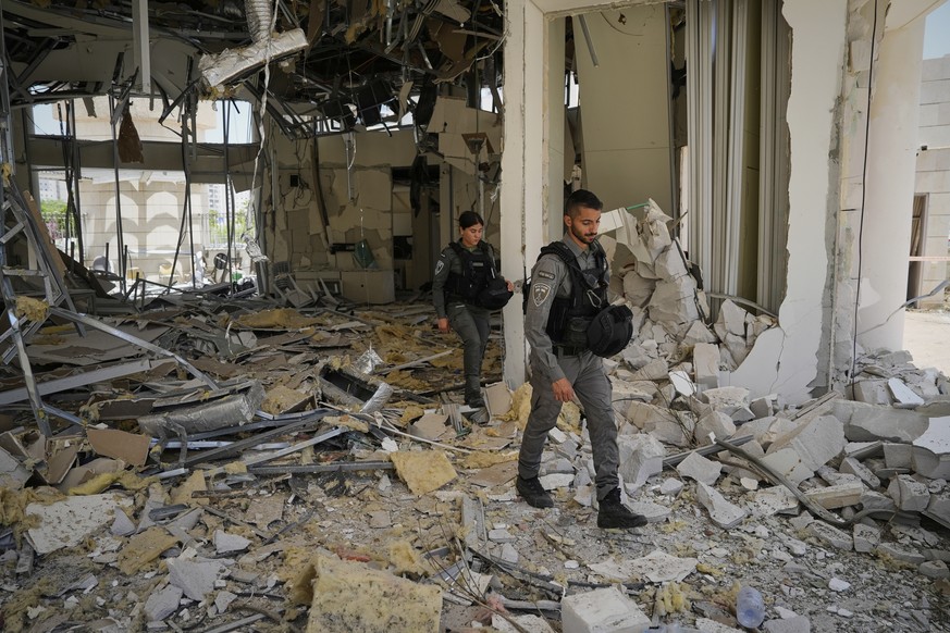 Israeli border police officers walk at the entrance of a residential building hit by a missile launched from Iran, in Petah Tikva, Israel, Monday, June 16, 2025. (AP Photo/Baz Ratner)
Israel Iran Mide ...