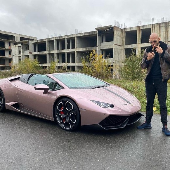 Wow! Qu'est-ce qu'il est cool, il pose avec une Lambo couleur lilas devant un immeuble pas fini.