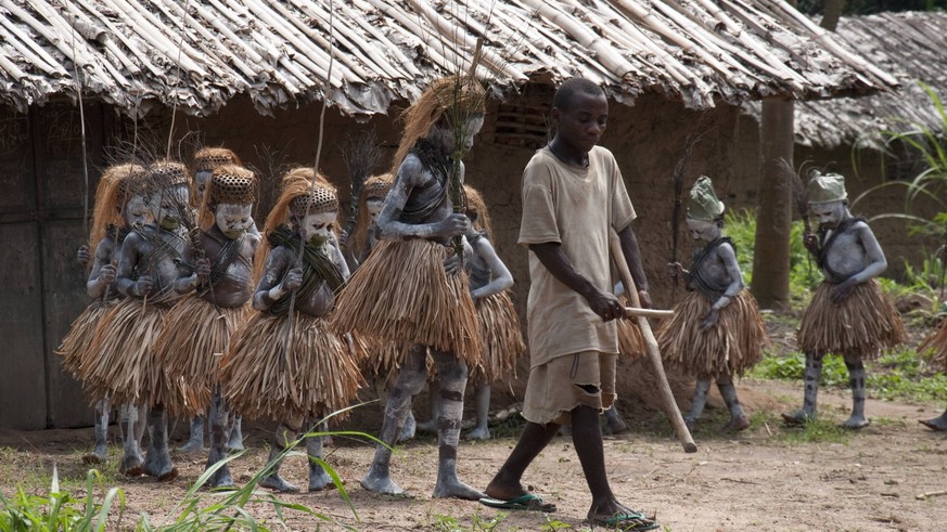 Mbuti Pygmy boys in traditional blue body paint and straw skirts, on way to forest to undergo initiation ceremony, which is a right of passage into manhood. Ituri Rainforest, Democratic Republic of th ...