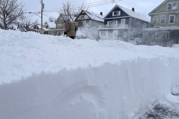 Martin Haslinger clears snow from the front of his home, Sunday, Dec. 25, 2022, in Buffalo, N.Y. Millions of people hunkered down against a deep freeze Sunday morning to ride out the frigid storm that ...