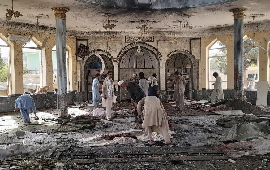 People view the damage inside of a mosque following a bombing in Kunduz, province northern Afghanistan, Friday, Oct. 8, 2021. A powerful explosion in the mosque frequented by a Muslim religious minori ...