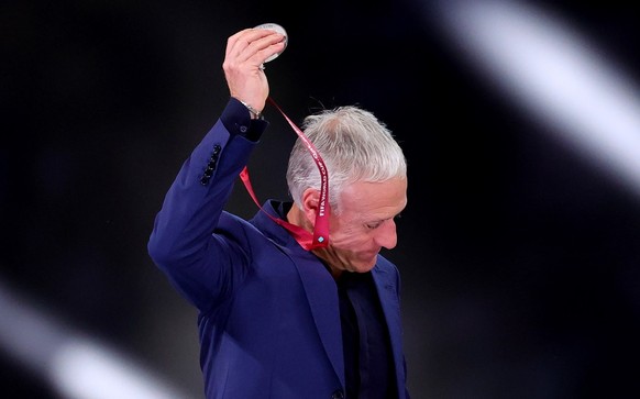epa10373041 Head coach Didier Deschamps of France takes off his runner-up medal after the FIFA World Cup 2022 Final between Argentina and France at Lusail stadium, Lusail, Qatar, 18 December 2022. EPA ...