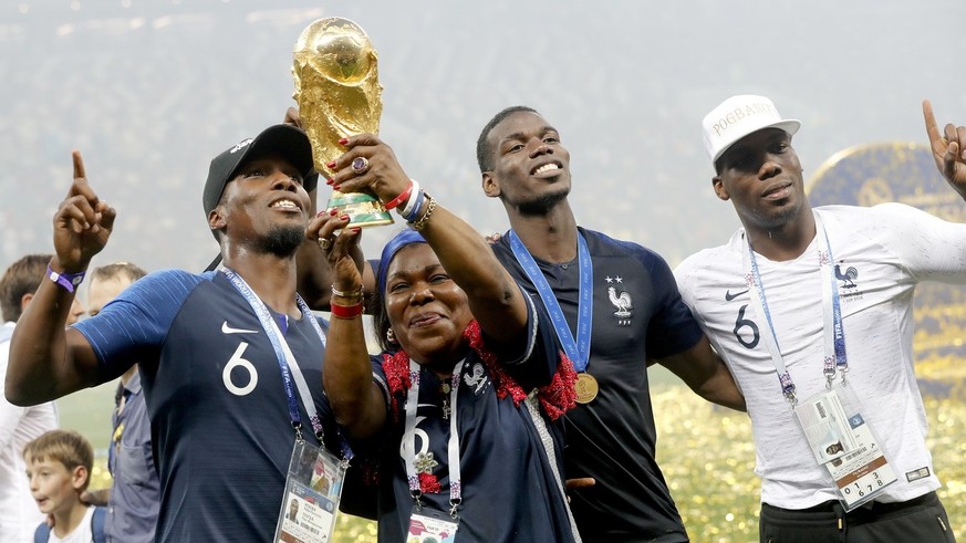 epa06893007 Paul Pogba (2R) of France and his brothers Florentin (L), Mathias (R) and their mother Yeo celebrate with the World Cup trophy after the FIFA World Cup 2018 final between France and Croati ...