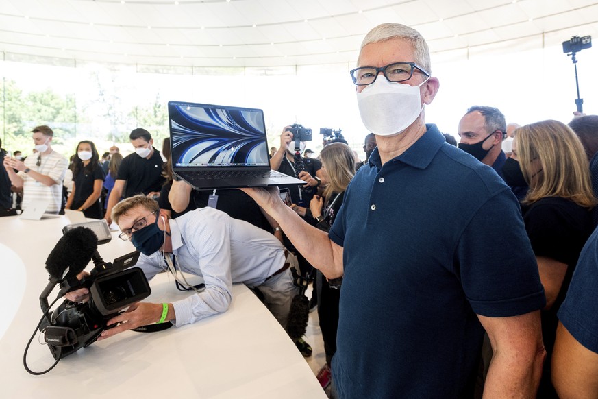 Apple CEO Tim Cook poses for photos as he holds one of the new Apple MacBook Air computers with an M2 processor, Monday, June 6, 2022, following the keynote presentation of Apple&#039;s World Wide Dev ...