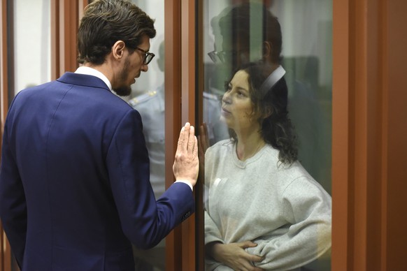 Ksenia Karelina, also known as Khavana speaks with her lawyer standing in a glass cage in a court room in Yekaterinburg, Russia, Thursday, Aug. 15, 2024. A Russian court on Thursday sentenced U.S.-Rus ...