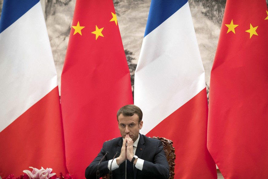 French President Emmanuel Macron watches a signing ceremony between French and Chinese firms at the Great Hall of the People in Beijing, Tuesday, Jan. 9, 2018. (AP Photo/Mark Schiefelbein, Pool)