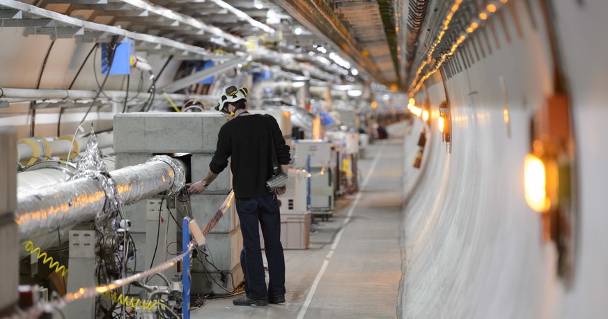 FILE - A technician works in the LHC (Large Hadron Collider) tunnel of the European Organization for Nuclear Research, CERN, during a press visit in Meyrin, near Geneva, Switzerland, Feb. 16, 2016. Th ...