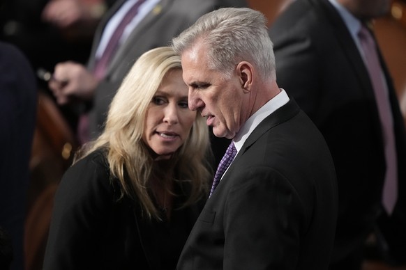 Rep. Marjorie Taylor Greene, R-Ga., and Rep. Kevin McCarthy, R-Calif., look at vote totals during the roll call vote on the motion to adjourn for the evening in the House chamber as the House meets fo ...