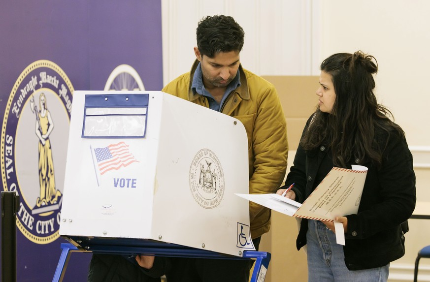epa10294172 People in a voting booth at a polling site in Brooklyn Borough Hall in the Brooklyn borough of New York, New York, USA, 08 November 2022. The US midterm elections are held every four years ...