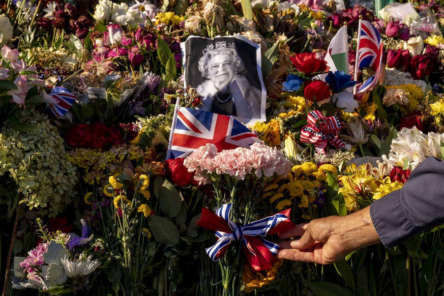 British Embassy head gardener John Sonnier tends to flowers left outside the British Embassy in Washington, Monday, Sept. 19, 2022, on the day of the funeral for Queen Elizabeth II. (AP Photo/Andrew H ...