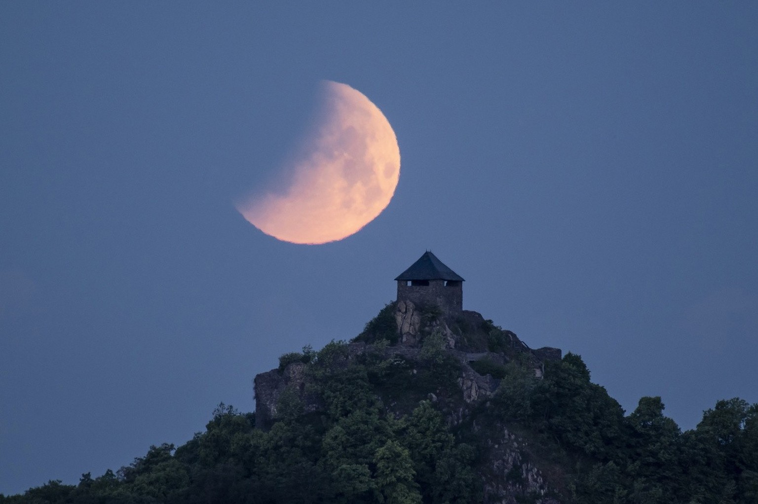 La lune pendant une éclipse au-dessus du château de Salgo, vue de Salgotarjan, Hongrie, début du 16 mai 2022.