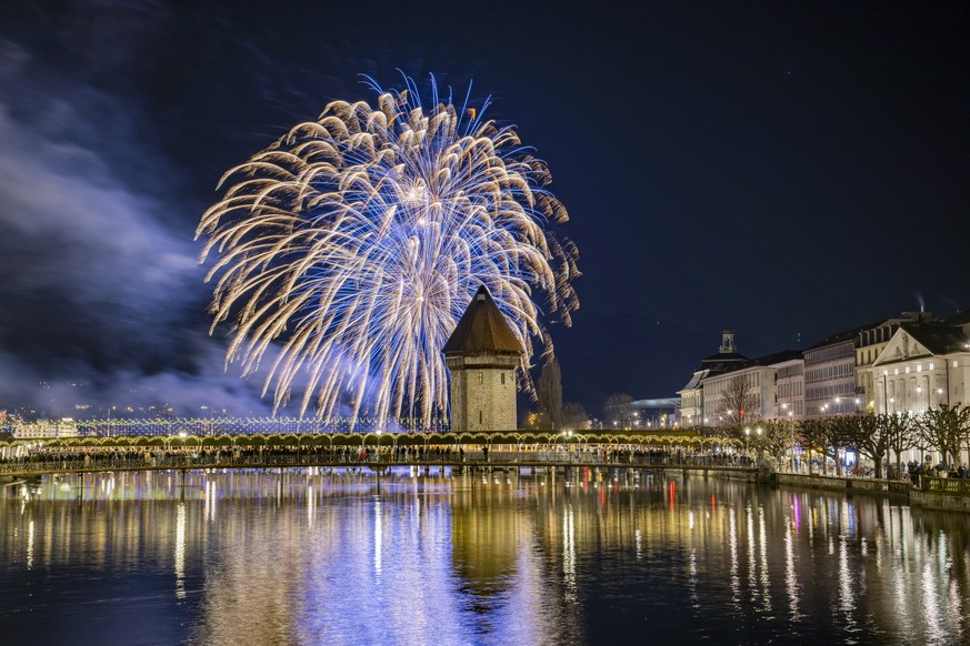 The New year fireworks explode over the famous Chapel Bridge and Old Town in Lucerne, Switzerland, on Monday, January 1, 2024. (KEYSTONE/Urs Flueeler)..Mit einem Feuerwerk ueber dem Luzerner Seebecken ...