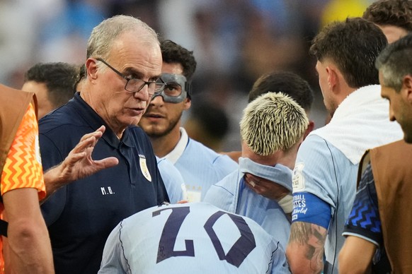 Uruguay head coach Marcelo Bielsa talks to his players during a hydration break in a World Cup Group H soccer match against Saudi Arabia in Miami Gardens, Fla., Monday, June 15, 2026. (AP Photo/Lynne  ...