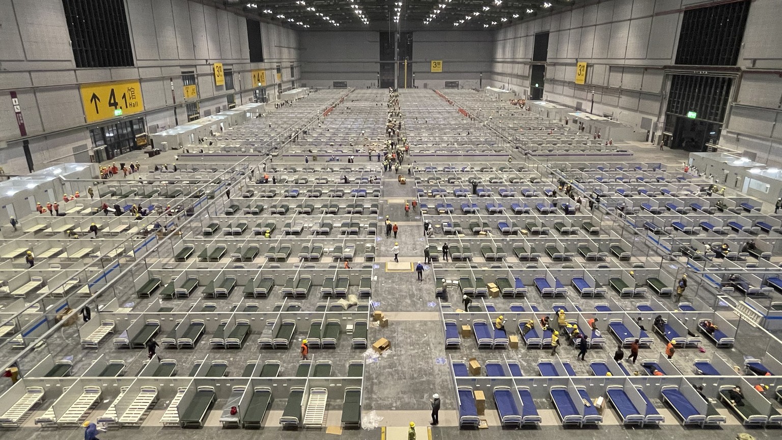In this photo released by Xinhua News Agency, workers labor at the site of a temporary hospital being constructed at the National Exhibition and Convention Center (Shanghai) in east China&#039;s Shang ...