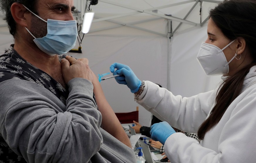 epa09626985 A man receives a dose of Covid-19 vaccine at a makeshift vaccination booth in Valencia, Spain, 07 December 2021. EPA/Juan Carlos Cardenas