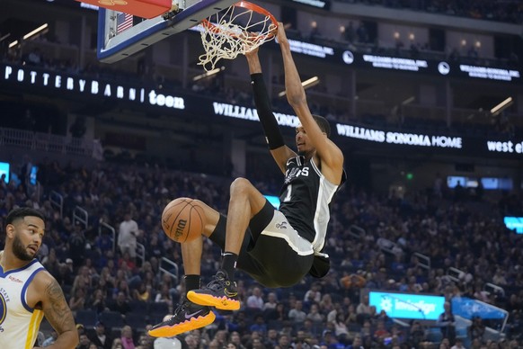 San Antonio Spurs center Victor Wembanyama (1) dunks against the Golden State Warriors during the first half of an NBA preseason basketball game in San Francisco, Friday, Oct. 20, 2023. (AP Photo/Jeff ...