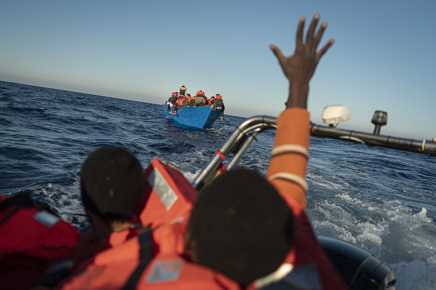 Migrants and refugees sailing adrift on an overcrowded wooden boat, are assisted by aid workers of the Spanish NGO Aita Mary in the Mediterranean Sea, about 114 miles (183 kms.) from Libya coast on Fr ...