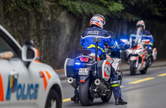 Une voiture police et des motards de la police genevoise, avec leurs feux bleus, signalent la presence d'une manifestation aux automobilistes, ce samedi 13 septembre 2025 a Geneve. (KEYSTONE/Salv ...